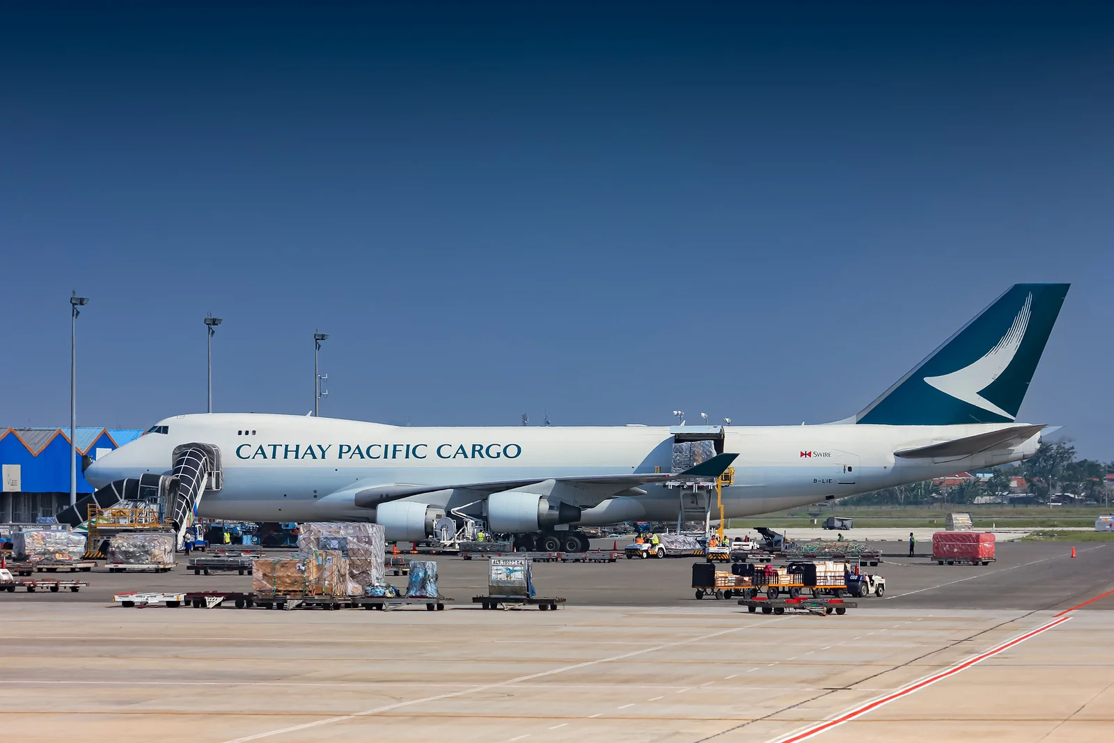 Cargo aircraft at an airport with loading equipment beside the fuselage.