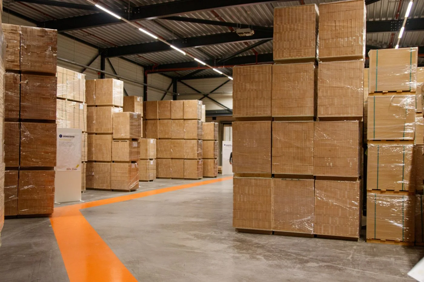 Wrapped pallets and cardboard cartons stored in a warehouse.